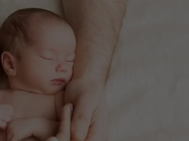 Manos de un hombre cogiendo a un bebé