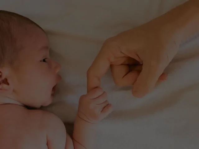 Bebé cogiendo dedo de un adulto