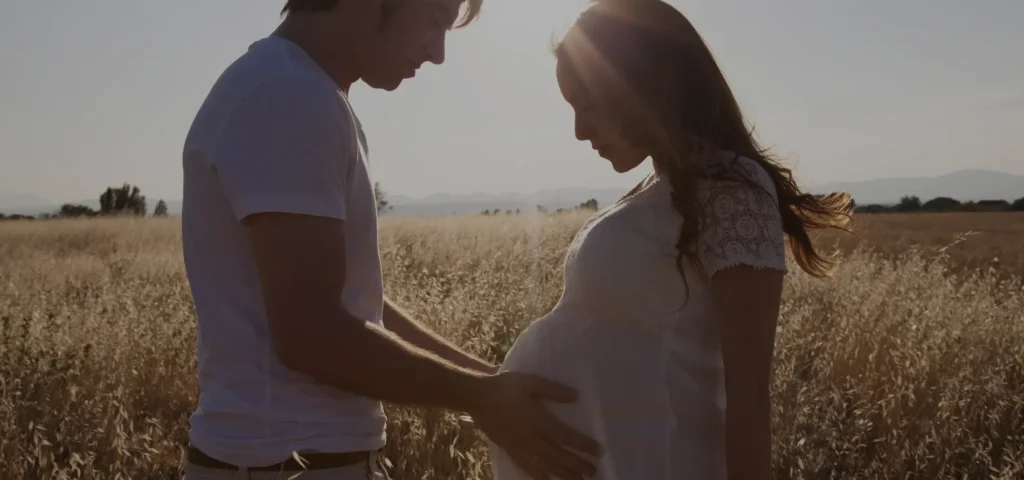 Hombre y mujer embarazada en el campo